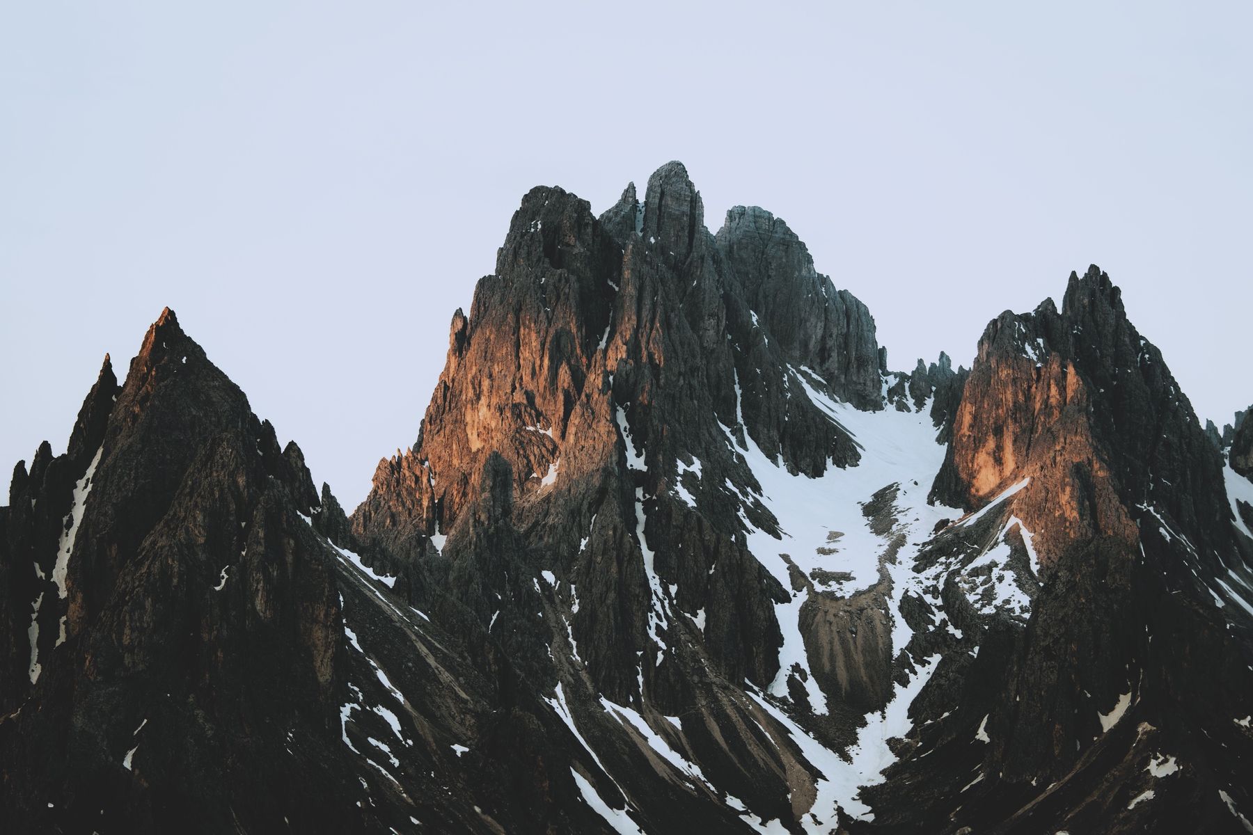 Dark jagged peaks catching orange light at dusk