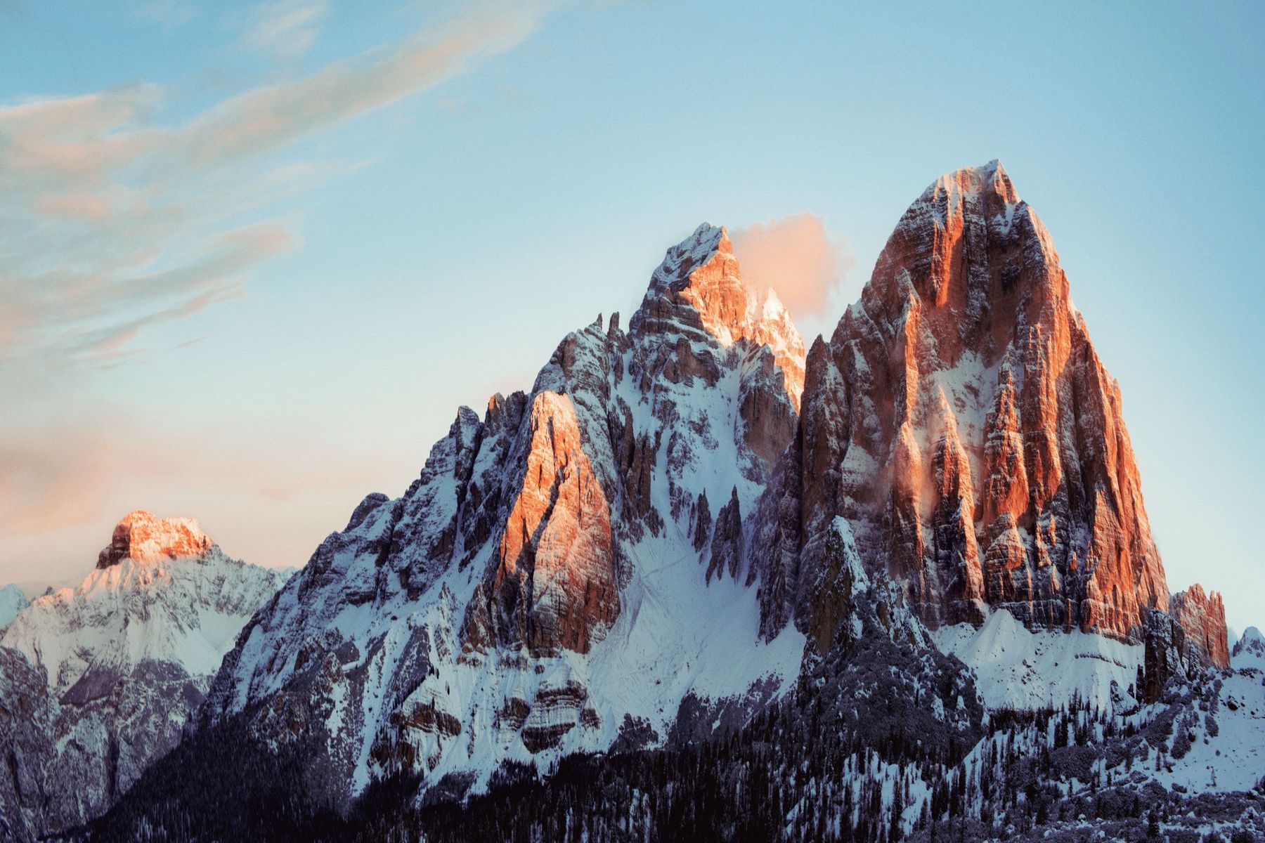 Snowy peaks glowing pink at sunrise